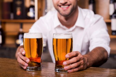 bardak bira ile dışarı uzanan barmen