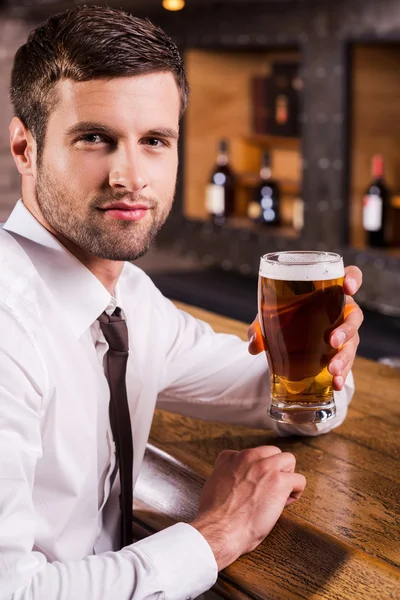 Ung man hålla glas med öl — Stockfoto