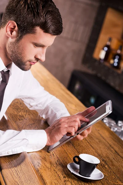 Homem sentado no bar e trabalhando em tablet — Fotografia de Stock