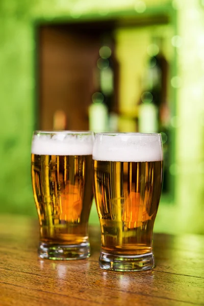 Glasses with beer at bar counter — Stock Photo, Image