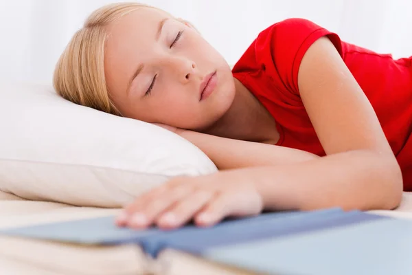 Meisje slapen en bedrijf hand op boek — Stockfoto