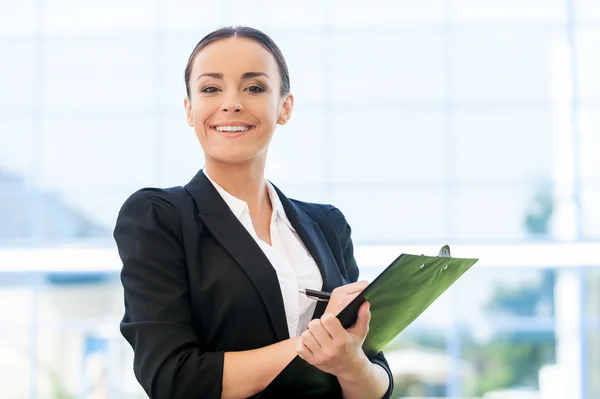 Femme en formalwear écriture dans le presse-papiers Photo De Stock