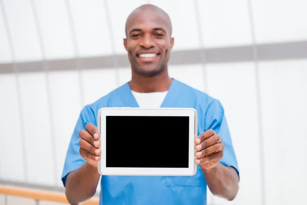 Африканский врач показывает цифровой планшет — стоковое фото