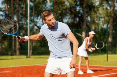 Tenis raketi holding ve uzağa bakarak adam