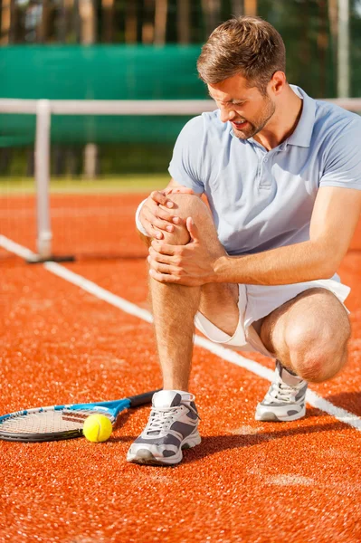 Tennisspelare röra knä och grimaserande — Stockfoto