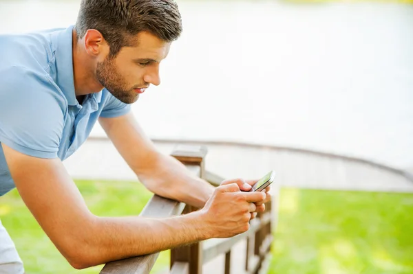 Молодий чоловік вводить повідомлення на мобільний телефон — стокове фото