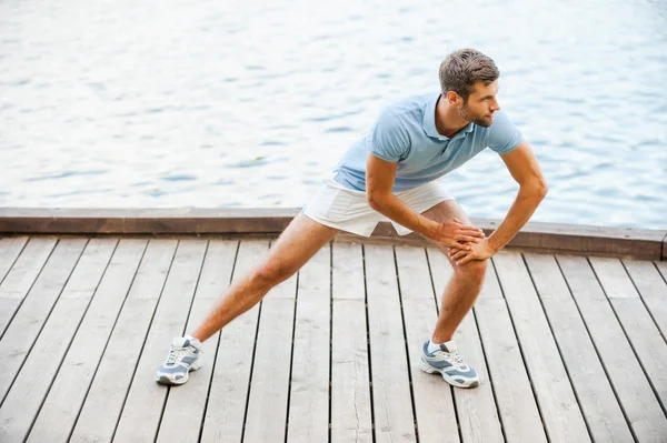 Jovem fazendo exercícios de alongamento — Fotografia de Stock