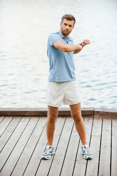 Joven ejercitándose en el muelle — Foto de Stock