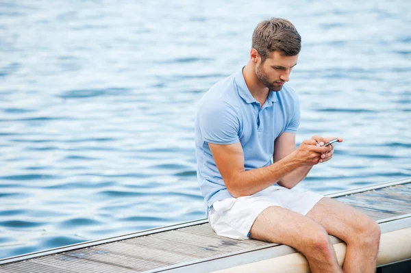 Bonito jovem segurando telefone celular — Fotografia de Stock