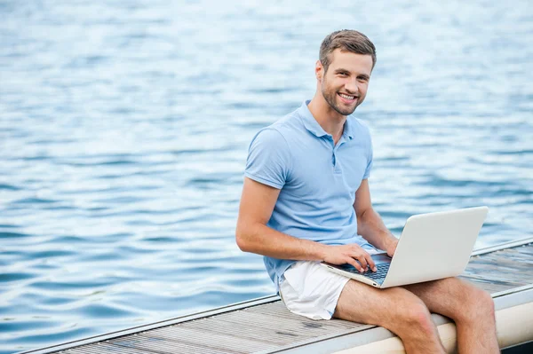 Handsome young man working on laptop — Stock Photo, Image