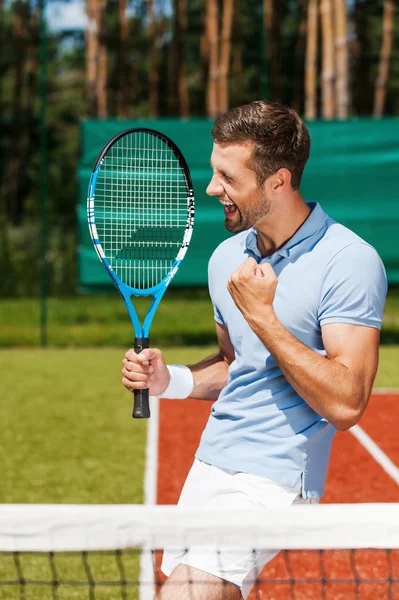 Hombre feliz sosteniendo raqueta de tenis y gestos —  Fotos de Stock