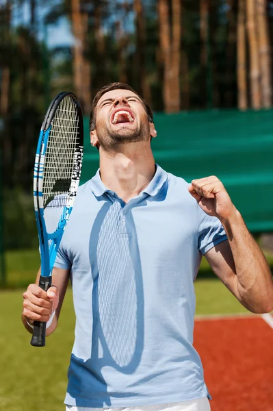 Jovem segurando raquete de tênis e gestos — Fotografia de Stock