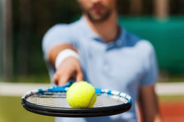 Uomo che tiene la palla da tennis sulla racchetta — Foto Stock