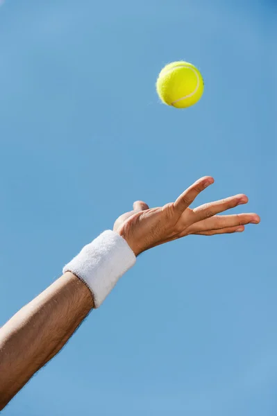 Mano maschile in braccialetto lancio palla da tennis — Foto Stock