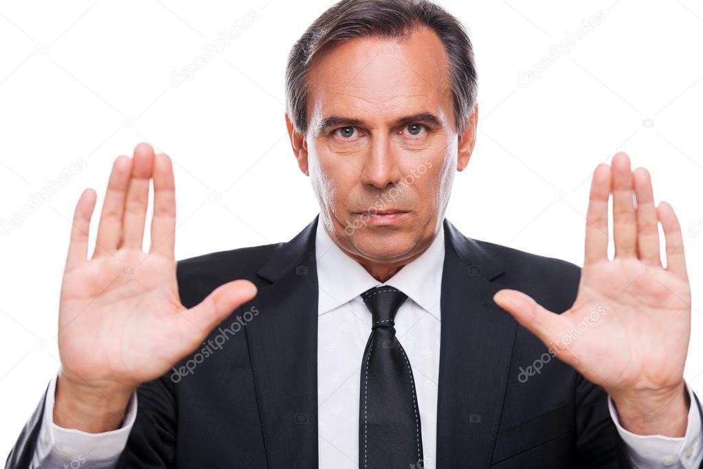 Serious mature businessman showing his palms