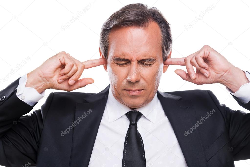 Confident mature businessman holding fingers in ears