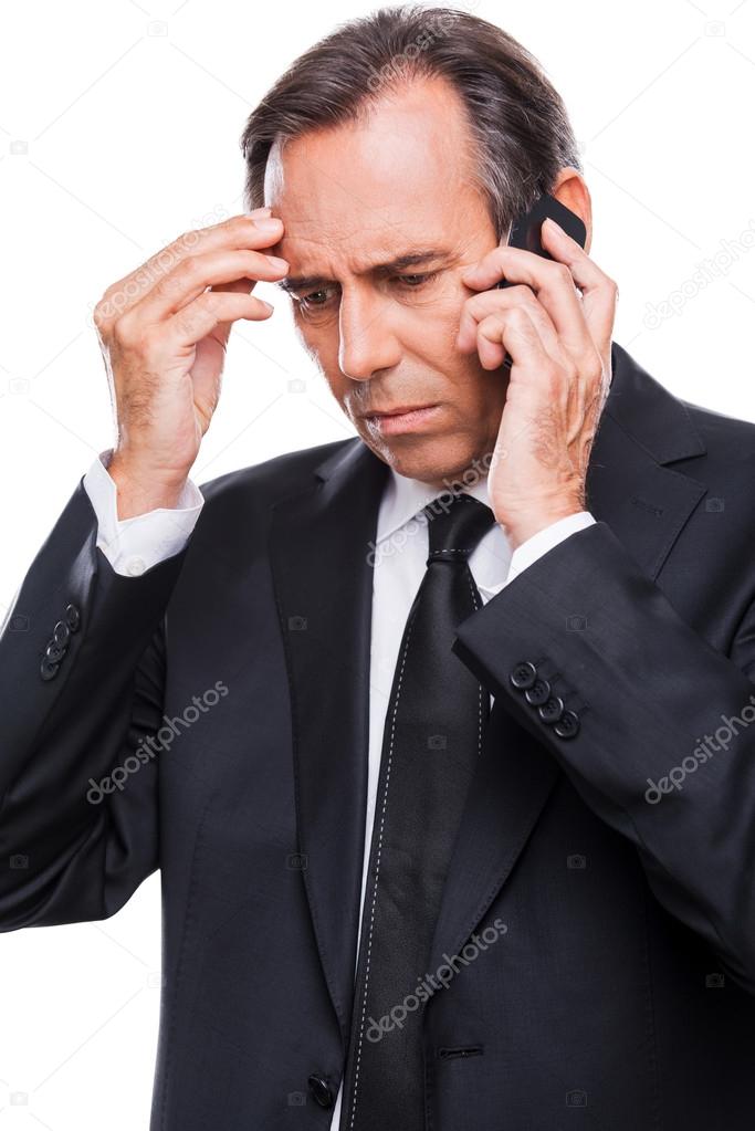 Frustrated businessman talking on mobile phone
