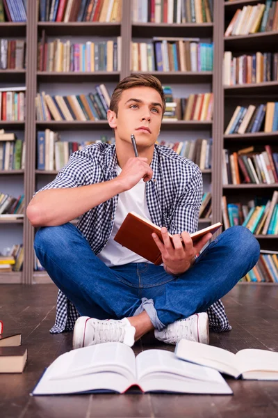 Thoughtful young man holding note pad — Stock Photo, Image