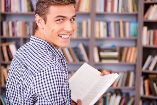 Gelukkig jonge man boek houden en kijkt uit over — Stockfoto