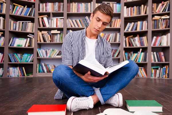 Jovem concentrado lendo livro — Fotografia de Stock