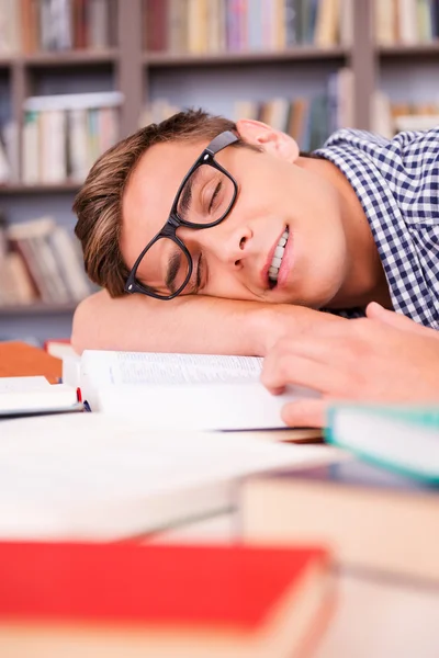 Jovem bonito dormindo na biblioteca — Fotografia de Stock