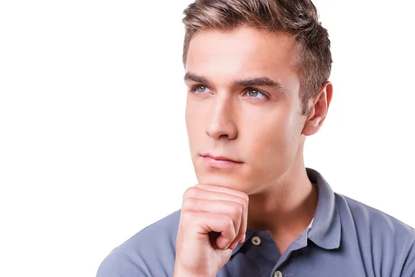 Thoughtful young man holding hand on chin — Stock Photo, Image