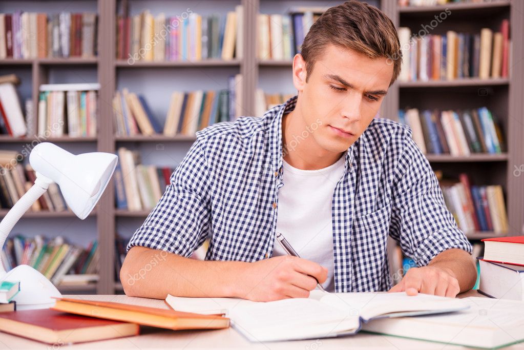 Confident young man making research in library