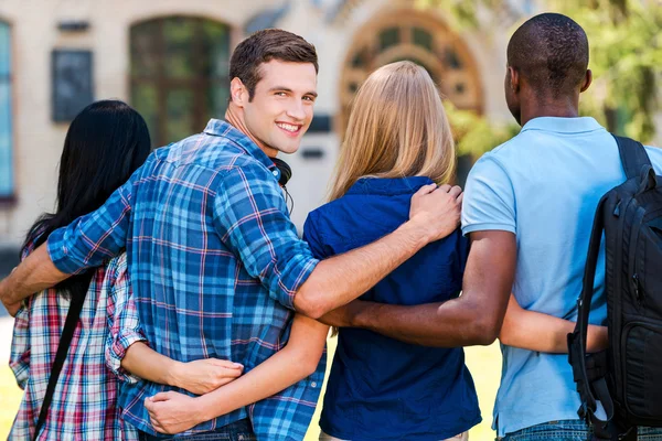 Handsome young man with friends — Stock Photo, Image