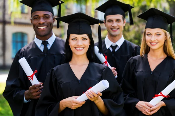 Graduados universitarios en vestidos de graduación — Foto de Stock