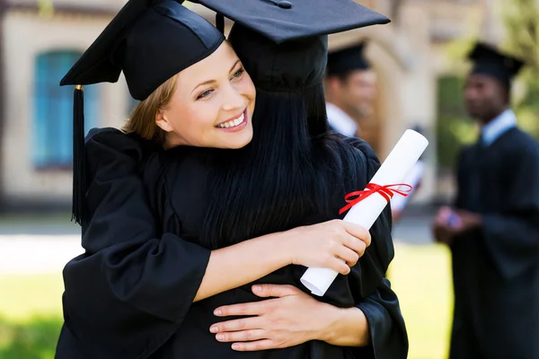 Mujeres felices en vestidos de graduación abrazándose — Foto de Stock