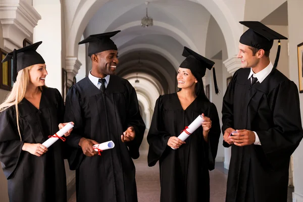 Graduados universitarios en vestidos de graduación — Foto de Stock