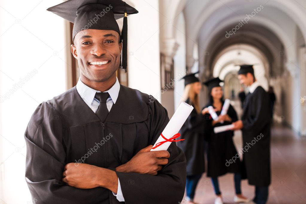 African man in graduation gown holding diploma