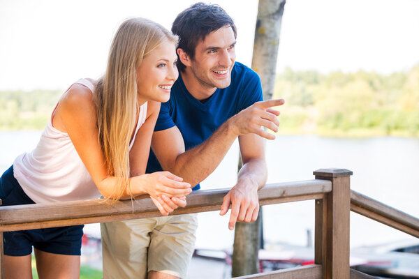 Loving couple leaning at the wooden railing