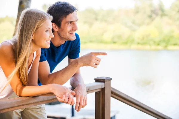 Loving couple leaning at the wooden railing — Stock Photo, Image