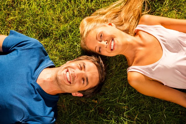 Couple lying on the green grass — Stock Photo, Image