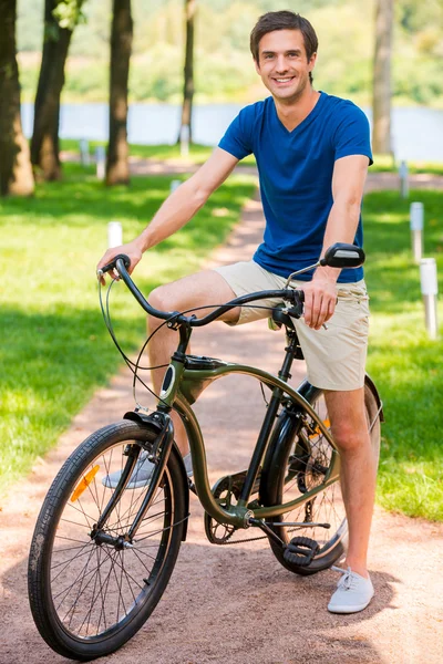 Young man riding bicycle in park — Stock Photo, Image