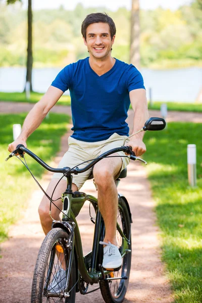 Young man riding bicycle in park — Stock Photo, Image