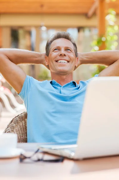 Relaxed mature man holding hands behind head — Stock Photo, Image