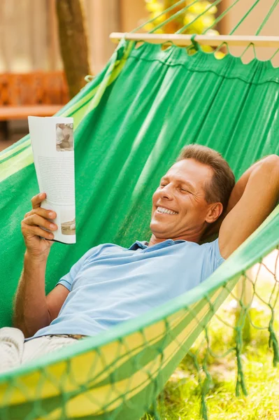 Man liggend in een hangmat en lezing magazine — Stockfoto