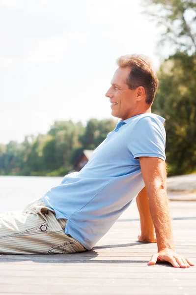 Dojrzały mężczyzna siedzący przy nabrzeżu — Zdjęcie stockowe