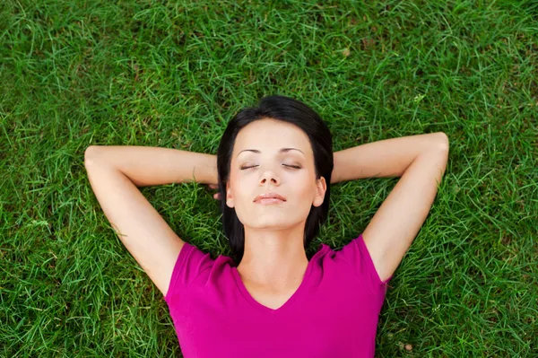 Женщина лежит на зеленой траве — стоковое фото