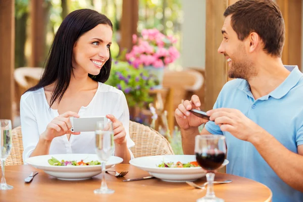 Casal tirando fotos de sua comida — Fotografia de Stock