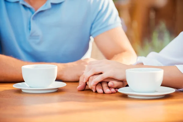 Pasangan berpegangan tangan di kafe trotoar — Stok Foto