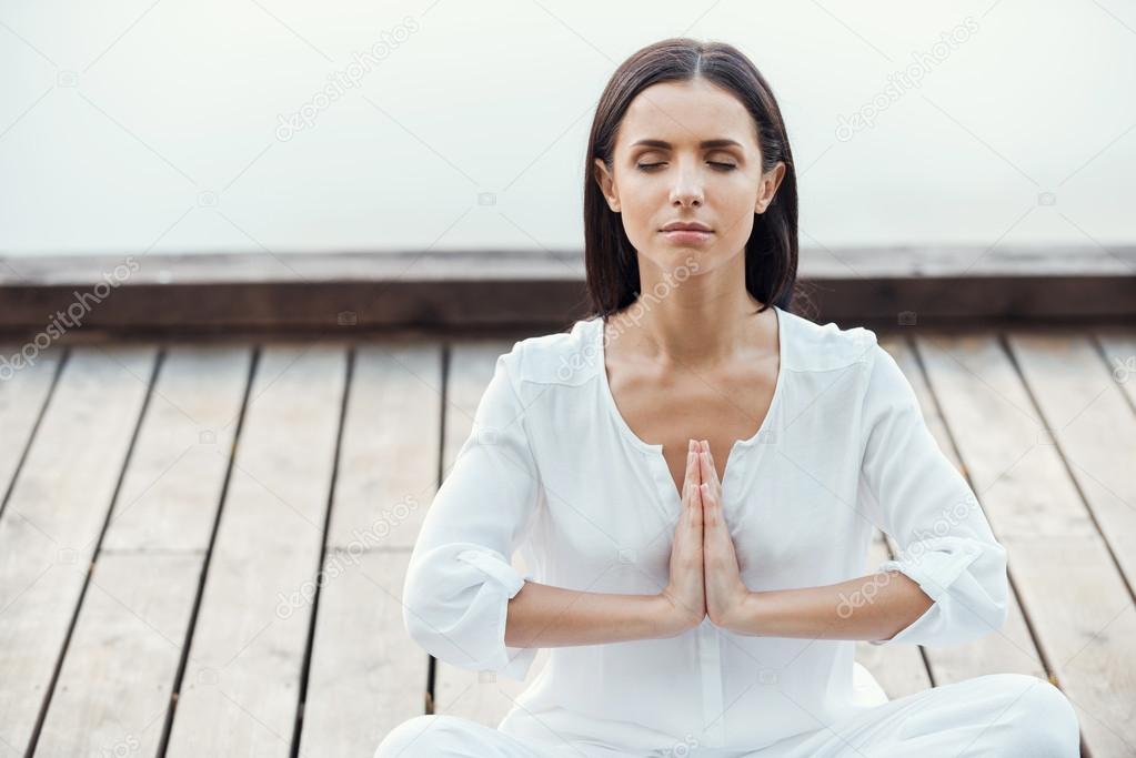 Woman in white clothing sitting in lotus