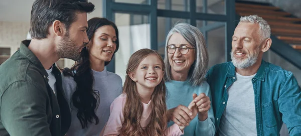 Feliz familia pasando tiempo juntos y sonriendo mientras están sentados —  Fotos de Stock