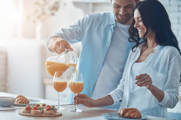 Feliz joven pareja preparando el desayuno juntos mientras pasa t — Foto de Stock