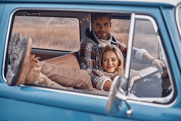 Mooi jong liefdevol paar genieten van road trip samen terwijl zitten op de voorstoelen van retro mini van — Stockfoto