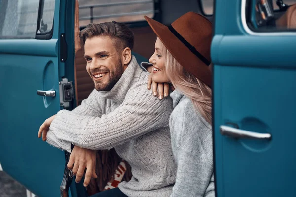 Piękna młoda kochająca się para nawiązująca więź i uśmiechająca się podczas spędzania czasu w minivanie — Zdjęcie stockowe