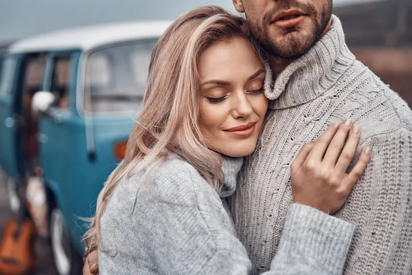 Beau jeune couple aimant embrasser tout en passant du temps près de leur minivan rétro à l'extérieur — Photo