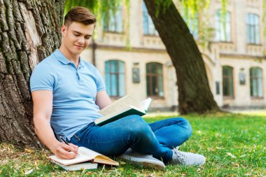 kitap okumak ve not defterinde öğrenci